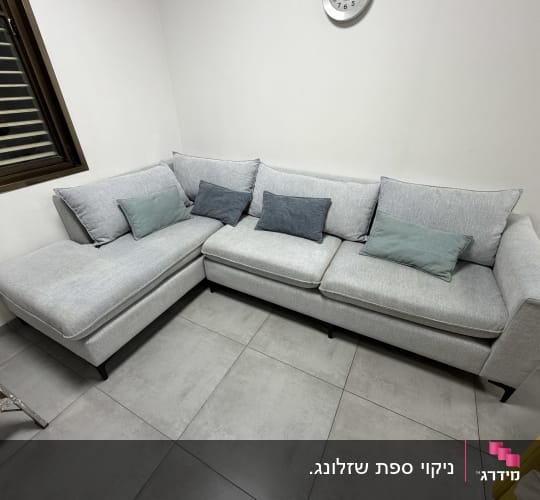 ספה אפורה עם כריות צבעוניות בחדר פנימי